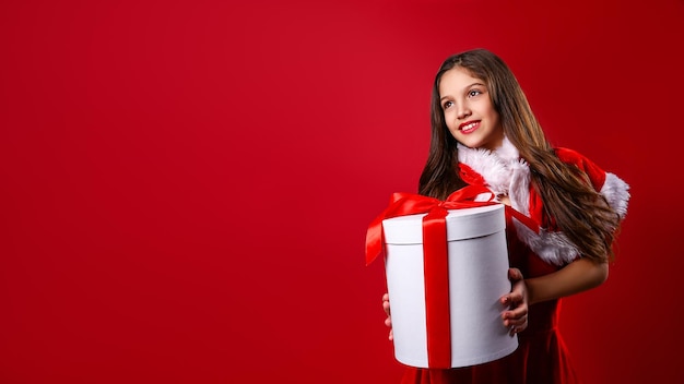 Hermosa niña en traje festivo espera caja de regalo decoración navideña diversión navideña