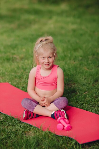 Una hermosa niña ucraniana de 7 años con el pelo blanco como un ángel se dedica al fitness