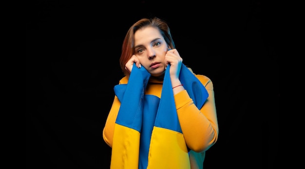 Hermosa niña ucraniana con la bandera del estado nacional de Ucrania sobre fondo negro Copiar espacio Ruso Guerra ucraniana Ayuda y ora por Ucrania Detener la guerra