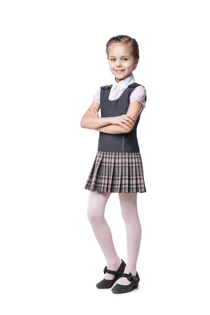 Hermosa niña en uniforme escolar aislado en blanco
