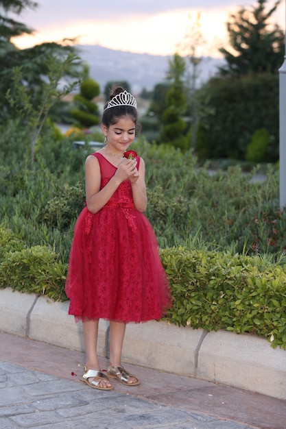 Hermosa niña vestida de princesa con el parque de la casa de campo al aire libre