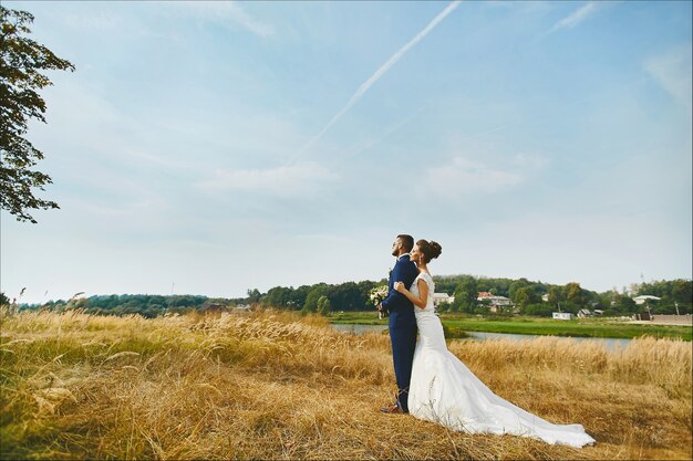 Hermosa novia abrazando al novio tiernamente en un campo de trigo en algún lugar del campo pareja amorosa