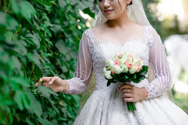 Hermosa novia en un campo de flores La chica en un ingenio de vestido blanco