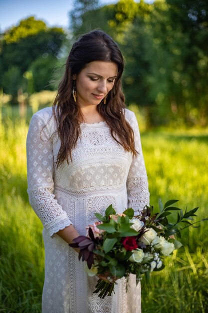 Hermosa novia día de la boda al aire libre mujer recién casada feliz con ramo de flores de matrimonio