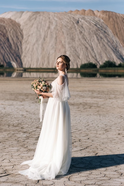 Hermosa novia elegante en el fondo de las canteras de arena salada