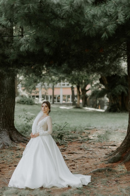 Hermosa novia elegante posando junto a la antigua muralla del castillo