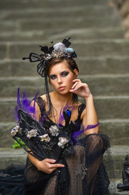 Hermosa novia con estilo en un vestido negro se sienta en las escaleras en Florencia, Italia.