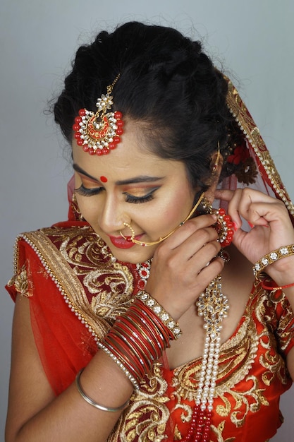 Hermosa novia india con mucho maquillaje y atuendo nupcial tradicional indio con aretes