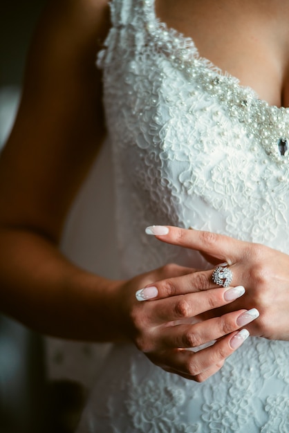 Hermosa novia lleva joyas por la mañana el día de su boda