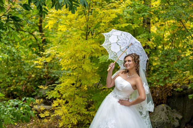 Hermosa novia con maquillaje elegante en vestido blanco