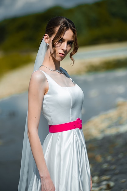 hermosa novia de moda en el día de la boda al aire libre en el río