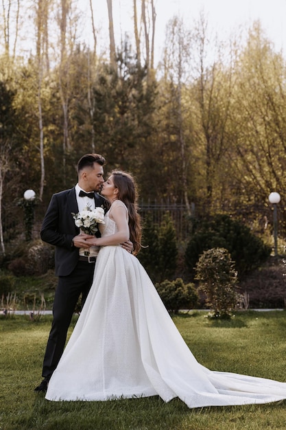 Hermosa novia y novio al atardecer en la naturaleza verde.