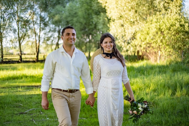 Hermosa novia y novio con bengalas en un prado