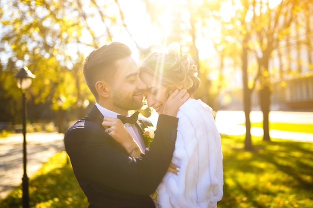 Foto la hermosa novia y el novio disfrutan mutuamente de la sonrisa a la sombra de un velo volador, un buen día de boda