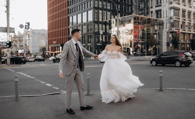 Hermosa novia y novio europeos caminando por las calles Mujer sostiene la mano del hombre