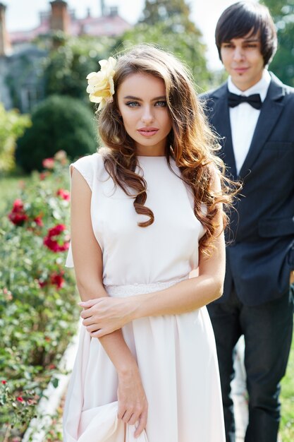 Hermosa novia y el novio de pie cerca uno del otro en el parque, foto de boda, hermosa pareja, retrato de cerca.