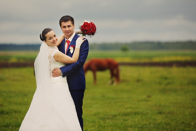 Hermosa novia y el novio posando en la naturaleza