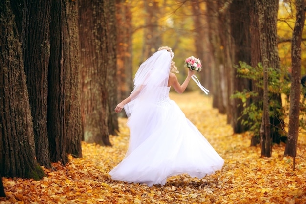 Hermosa novia en el parque otoño