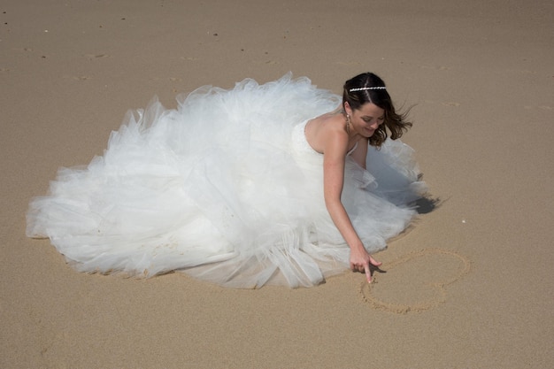 Hermosa novia en la playa con vestido de novia