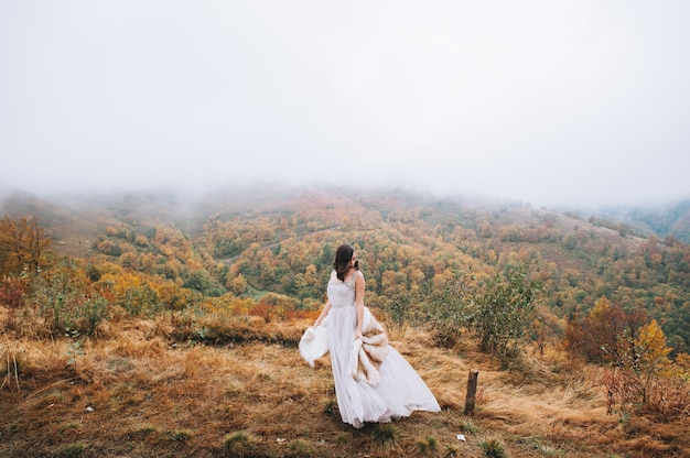 Hermosa novia posando en el paisaje de alta montaña