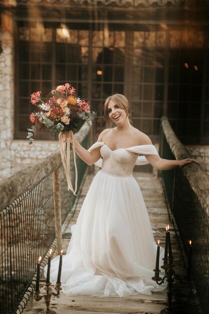 Foto hermosa novia posando en un puente de madera lleno de velas