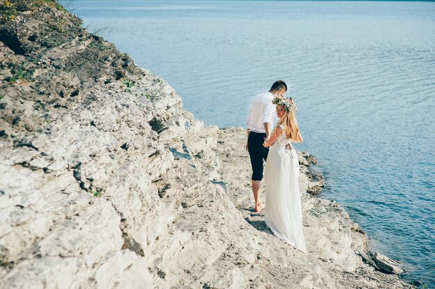 hermosa novia rubia hermosa y elegante novio, en el fondo de un mar