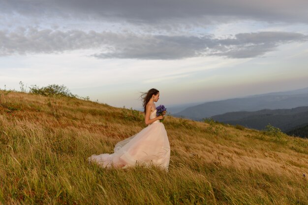 Hermosa novia en su vestido de novia en la montaña