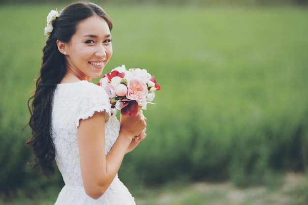 Una hermosa novia tiene un ramo en sus manos. Boda. Amor feliz .