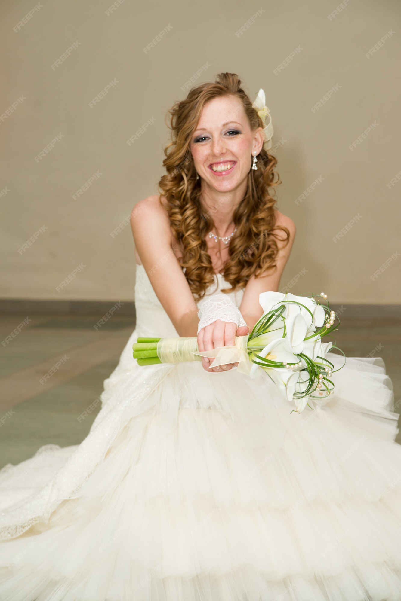 Hermosa novia con un vestido blanco con un ramo de alcatraces | Foto Premium