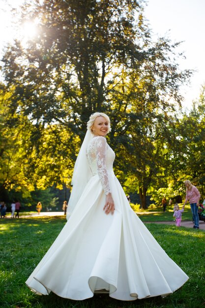 Hermosa novia en vestido delicado al aire libre