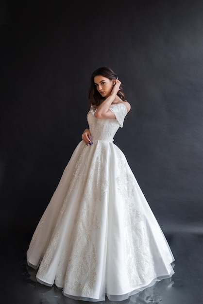 Hermosa novia con vestido de novia en un interior oscuro