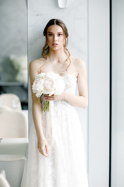 Hermosa novia con un vestido de novia de moda en un hermoso restaurante