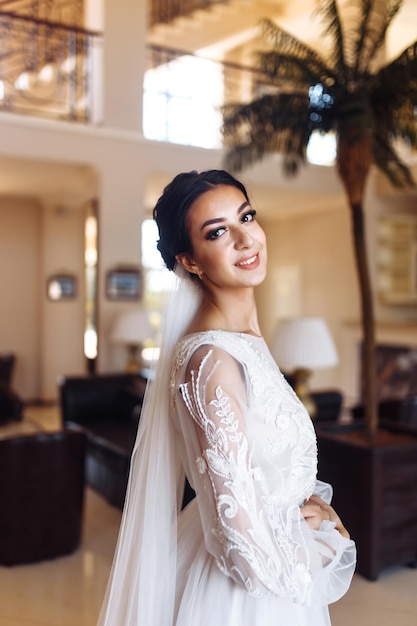 Hermosa novia en vestido de novia de moda con un largo velo de lujo Impresionante novia es increíblemente feliz