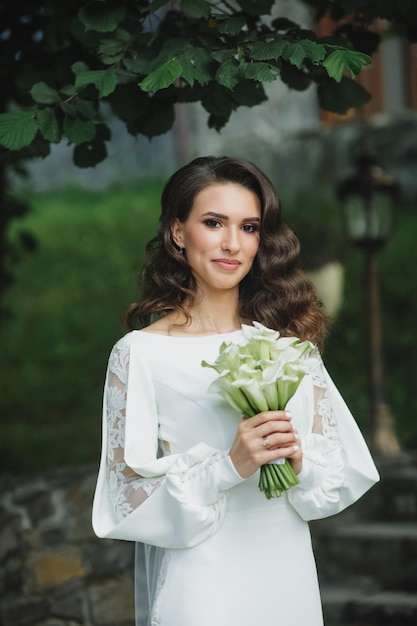 Hermosa novia en vestido de novia de moda sobre fondo natural.