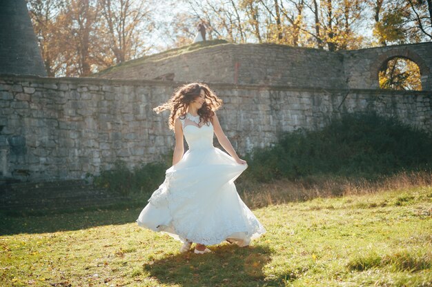 hermosa novia en un vestido de novia en el parque de otoño