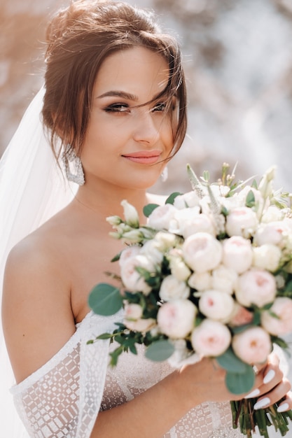 Hermosa novia en un vestido de novia con un ramo de flores en la cima de las montañas de sal. Una deslumbrante joven novia de pelo rizado. Día de la boda. . Hermoso retrato de la novia sin el novio