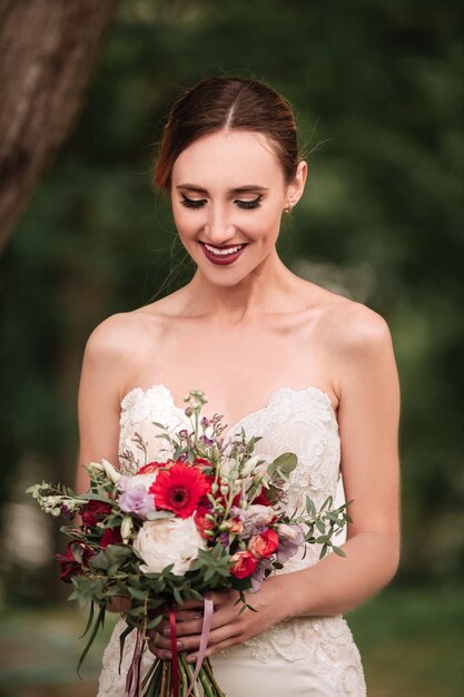 Hermosa novia con un vestido de novia y un ramo de novia