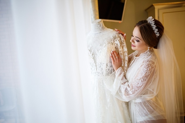 Hermosa novia viste su vestido de novia blanco