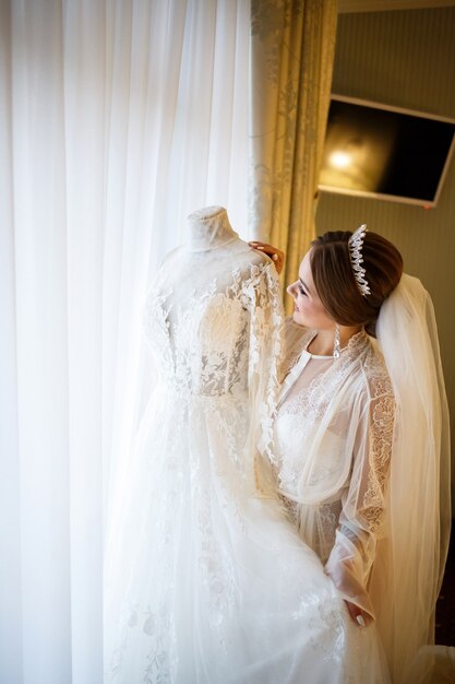 Hermosa novia viste su vestido de novia blanco