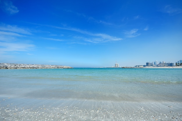 Hermosa orilla del mar y ciudad moderna construida en el horizonte.