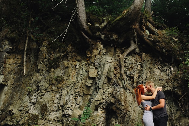 Hermosa pareja abrazándose cerca de un río de montaña