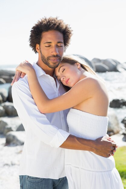 Hermosa pareja abrazándose en la costa