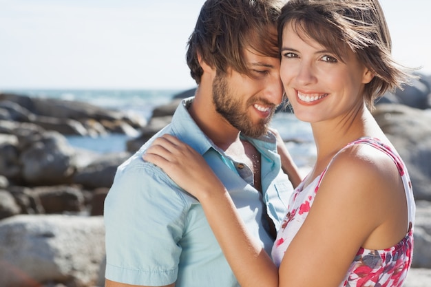 Hermosa pareja abrazándose en la costa