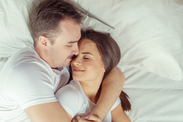 Hermosa pareja acostada en la cama