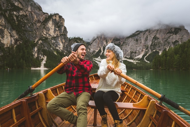 Hermosa pareja de adultos jóvenes visitando un lago alpino en Braies Italia