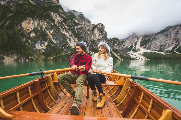 Hermosa pareja de adultos jóvenes visitando un lago alpino en Braies Italia