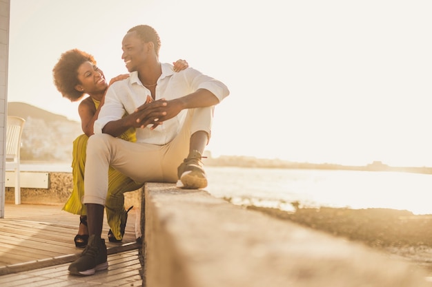 Hermosa pareja africana de raza negra en el amor y las vacaciones se sientan disfrutando juntos