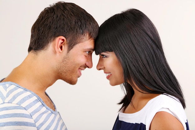 Hermosa pareja amorosa juntos sobre fondo gris