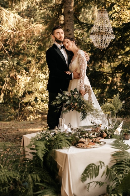 Hermosa pareja amorosa de recién casados en el bosque, boda en la naturaleza