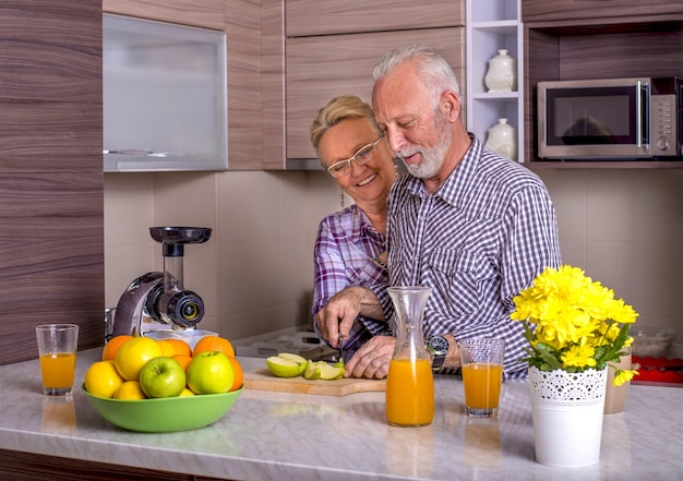 Hermosa pareja de ancianos cocinando en la cocina con los demás
